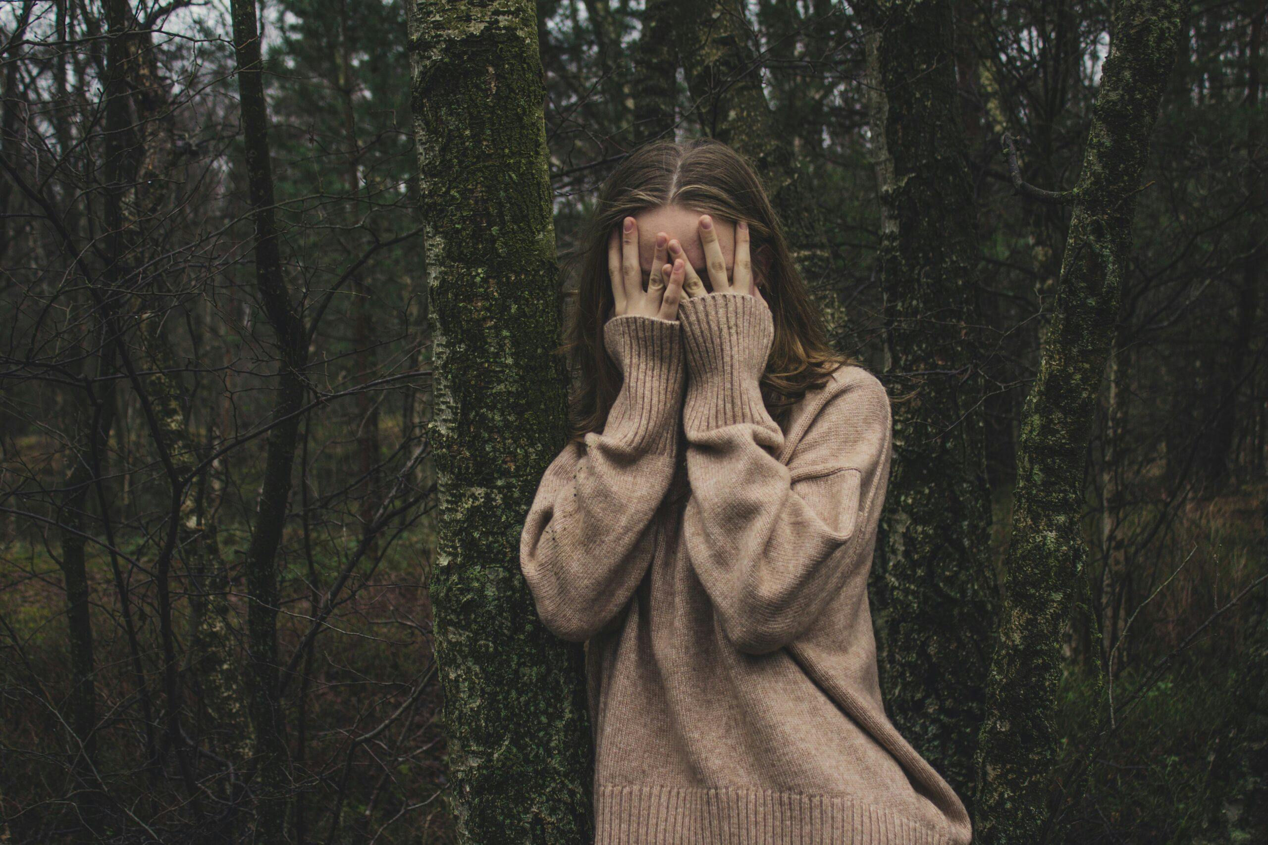 a girl covering her face with her hands